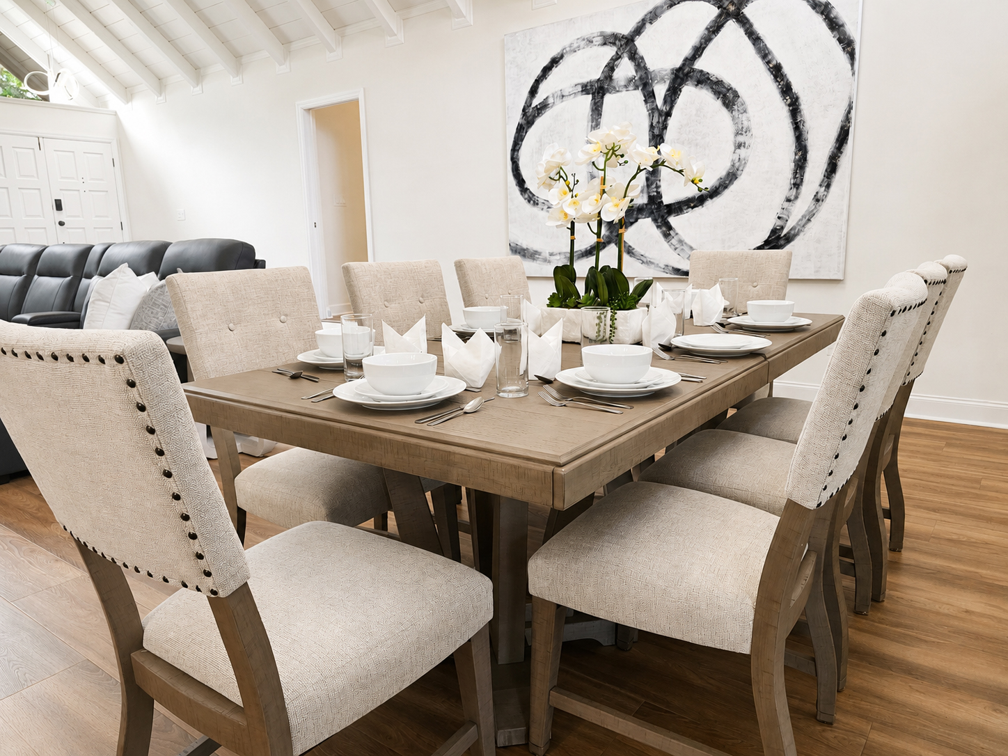 Dining table set for eight beside the living room