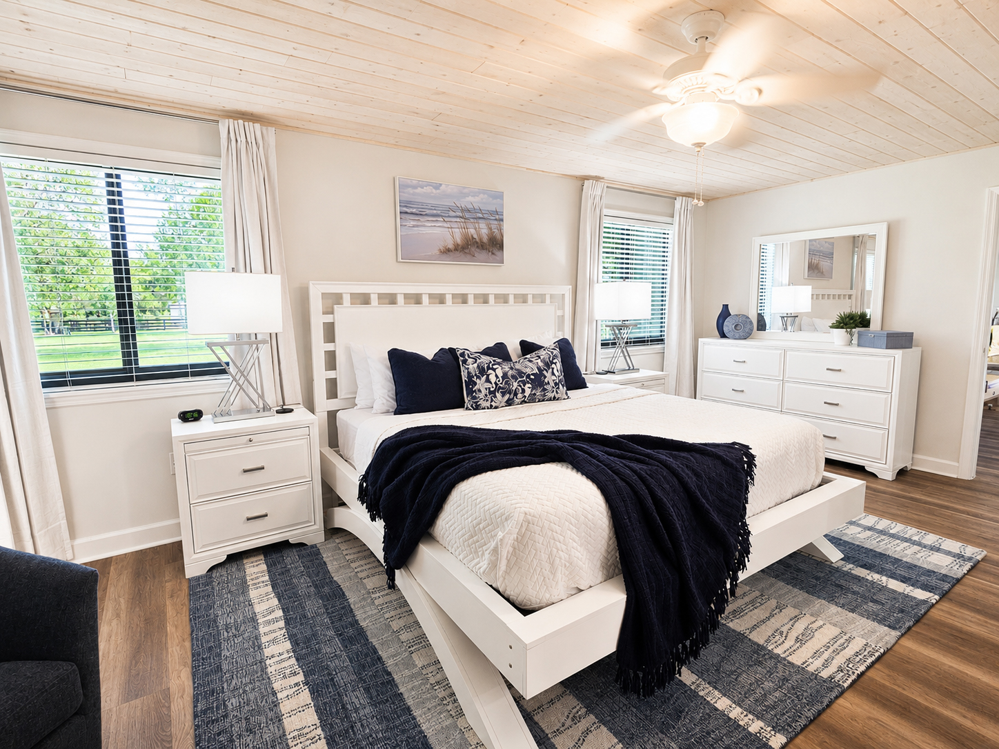 Coastal master bedroom with king bed and garden views