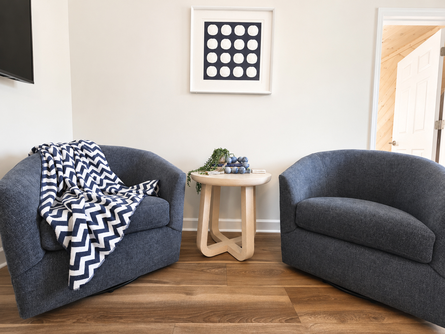 Sitting area with swivel armchairs and wall-mounted TV