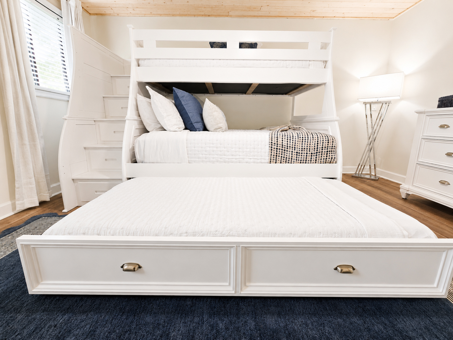 White bunk bed room with full bed below and twin bed above
