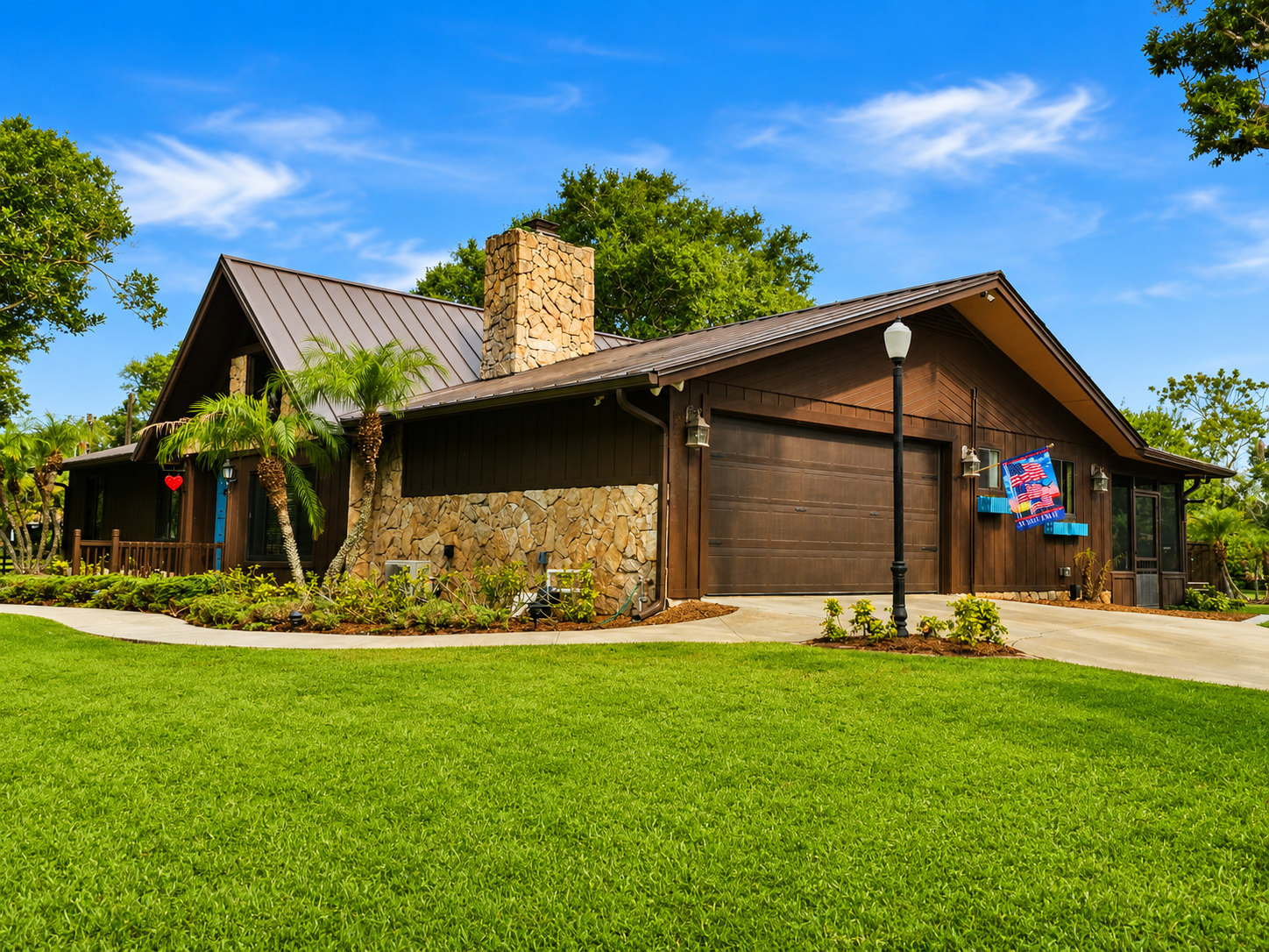 Sanctuary at Twin Ponds exterior with stone chimney, lush lawn and blue front door